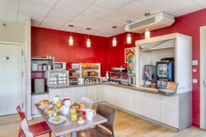 里永里永艾斯酒店的一间厨房,拥有红色的墙壁和一张带食物的桌子