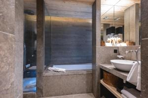 梅杰夫L'Alpaga, a Beaumier hotel的浴室配有盥洗盆和浴缸。