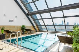 美因河畔法兰克福法兰克福丽笙酒店的一座带窗户的建筑中的游泳池