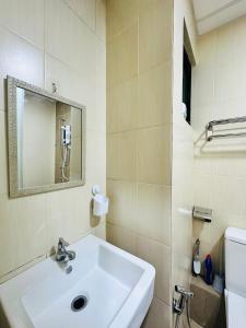宾南邦ITCC Manhattan Suites by AURORA的浴室设有白色水槽和镜子