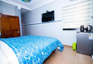 NsimalenNK HOME的一间卧室配有一张床和一台平面电视