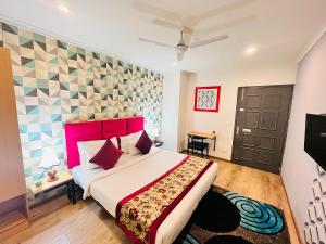 新德里Qotel Hotel Chhatarpur- Opp Tivoli garden的一间卧室配有一张大床和红色床头板
