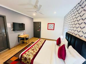 新德里Qotel Hotel Chhatarpur- Opp Tivoli garden的酒店客房设有一张大床和一张桌子。