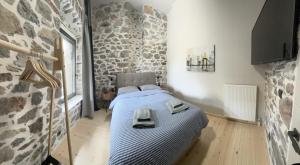 阿姆菲克利亚Amfikleia Earth houses的卧室配有一张石墙床