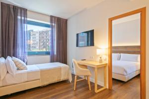 巴塞罗那巴塞罗那阿克塔阿祖尔酒店 的酒店客房带一张床、一张书桌和一面镜子