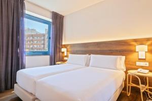 巴塞罗那巴塞罗那阿克塔阿祖尔酒店 的酒店客房设有一张白色大床和一个窗户。