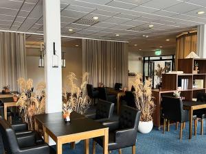 龙讷比龙讷比布伦酒店的一间设有桌椅和植物的会议室