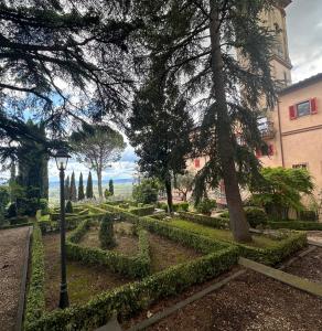 卡莱扎诺Monastero del 600 vista Firenze的一座花园,花园内有建筑、树木和街灯