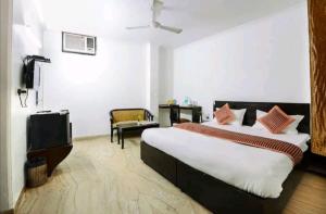 阿格拉Hotel First by Goyal Hoteliers的一间卧室配有一张大床和电视