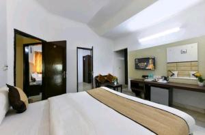 阿格拉Hotel First by Goyal Hoteliers的配有一张床和一张书桌的酒店客房