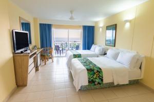 圣玛尔塔GHL Relax Hotel Costa Azul的酒店客房设有两张床和一台平面电视。