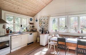 弗雷德里克斯伐克Cozy Home In Frederiksvrk With Kitchen的厨房配有白色橱柜和桌椅