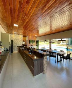 特林达迪sobrado luxo的一间带木制天花板和用餐室的厨房
