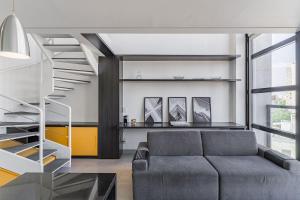圣保罗Flat duplex com serviço de camareira e enxoval completo - ao lado do parque Ibirapuera的带沙发和楼梯的客厅