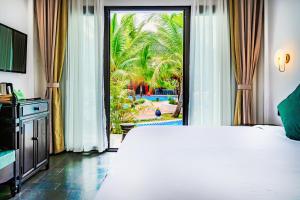 琅勃拉邦Manyo Hotel and Resort的一间卧室设有一张大床和一个滑动玻璃门