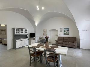 法萨诺马塞里亚唐桑特酒店的厨房以及带桌椅的起居室。
