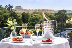 凡尔赛Waldorf Astoria Versailles - Trianon Palace的一张桌子,上面放着一瓶葡萄酒和一篮水果