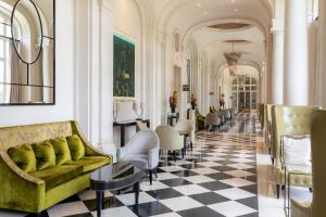 凡尔赛Waldorf Astoria Versailles - Trianon Palace的大堂设有绿色沙发和棋盘地板