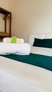 马拉戈日Pousada Enero的白色的床,上面有绿色的白色毛巾
