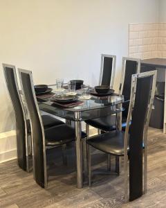 布雷得佛The Luxe By Elegant Aparts的餐桌、黑色椅子和带玻璃杯的黑色桌子