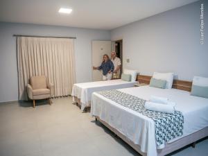 博多克纳HOTEL AGUAS DE BODOQUENA的两人站在带两张床的房间
