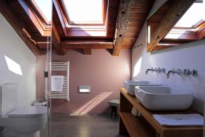卡斯特罗赫里斯波萨达印象酒店的一间带两个盥洗盆、卫生间和天窗的浴室。