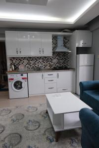 卡赫拉曼马什拉Çam Suit的厨房配有白色橱柜、沙发和桌子