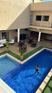 罗安达Convênio Residencial-Hotelaria & Turismo的建筑物游泳池里的人