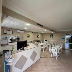 圣乔瓦尼·罗通多想象酒店的餐厅设有桌子、白色椅子和柜台