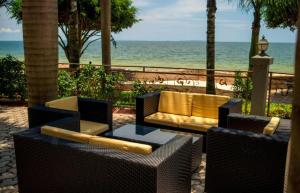 KisubiLake view property的一个带两把椅子和一张沙发的庭院和大海