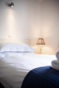 帕兹托特莱沃斯高尔夫乡村俱乐部的卧室配有白色的床和灯