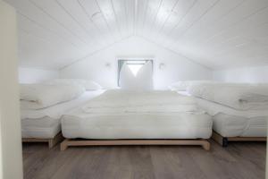瓦森贝格Amici Camping Urlaub am Effelder Waldsee的白色客房的三张床,设有窗户
