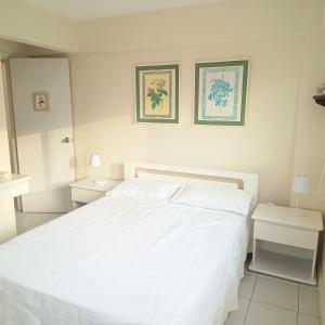 埃斯特角城ap frente mar Península Punta Del Este的白色卧室配有白色的床和2张桌子
