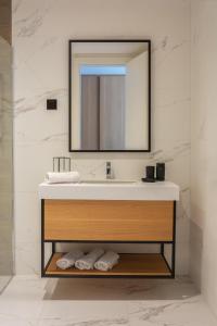 布德瓦Hotel & Spa Ponta Plaza的一间带水槽和镜子的浴室