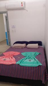 卡波布里奥Soul do Mar Hostel的床上有色彩缤纷的毯子