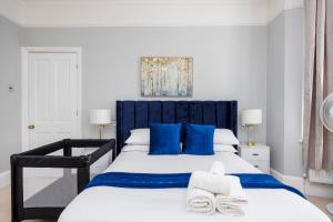 伦敦6 Bedroom House by AV Stays Acton Sleeps 11 Free Parking的一间卧室配有蓝色和白色的床和蓝色枕头