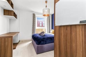 伦敦Nyland House的一间卧室配有一张紫色的床和镜子