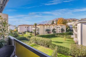 阿斯科纳Ferienwohnung Ascona Vista Verde的带庭院的公寓的阳台享有风景。