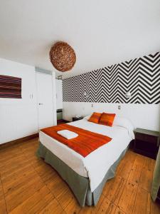 阿里卡Hotel Avenida en Arica的一间卧室配有一张带橙色枕头的大床