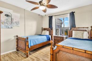 卡纳维拉尔角Cape Winds Resort的一间卧室配有两张床和吊扇