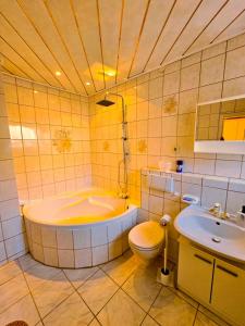 纽伦堡B&R Ferienhaus In der Nähe des Flughafens的带浴缸、卫生间和盥洗盆的浴室