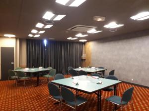 杜阿拉宜必思杜阿拉酒店的一间会议室,配有桌椅和屏幕