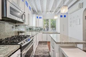 迈阿密海滩Villa Venezia BB full house up to 12 guests的厨房配有白色橱柜和炉灶。
