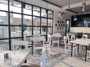 达累斯萨拉姆Serenity Suite With free Wi-Fi and Swimming pool的餐厅设有白色的桌椅和窗户。