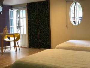 贾拉普帝国酒店的客房设有两张床、一张桌子和一扇窗户。