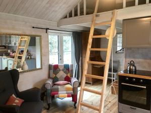 TingsrydPippis Cottage的客厅配有高架床和椅子