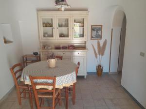 奇斯泰尼诺Trullo Il Giglio的厨房配有桌椅、桌子和橱柜。