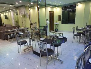 德奥加尔Hotel Shobhani的一间在房间内配有桌椅的餐厅