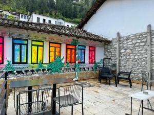 培拉特Helin's Hostel by Backpackers的庭院设有桌椅和色彩缤纷的窗户。