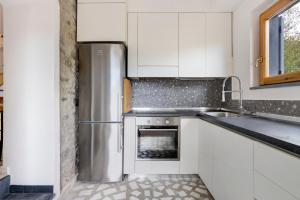 LuniVillino Marco的厨房配有白色橱柜和不锈钢冰箱